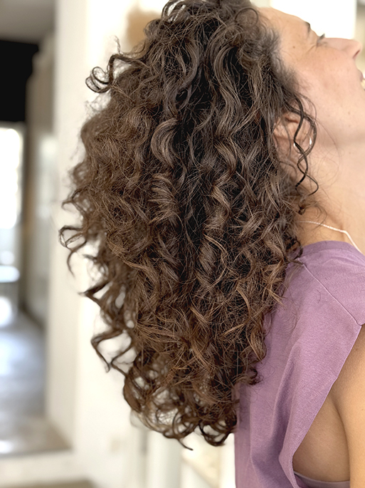 Frau mit gepflegten, perfekt gestylten Naturlocken. Sie hat unseren LOCKEN MACHER verwendet