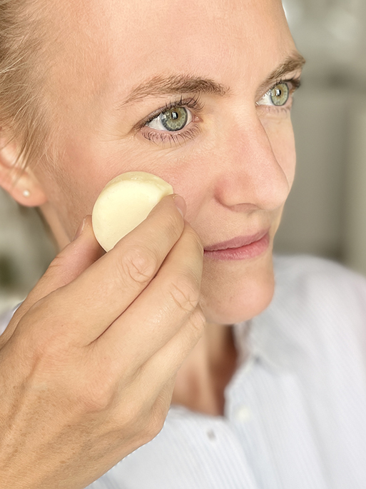 Frau streicht sich mit dem Cream Bar Gesichtspflege Bar ins Gesicht