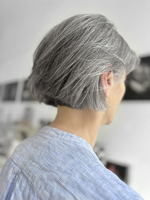 Graues Haar, lässiger Bob Cut nach hinten gestylt – perfekt für natürliche Haarpflegeprodukte, die gleichzeitig als Styling helfen.