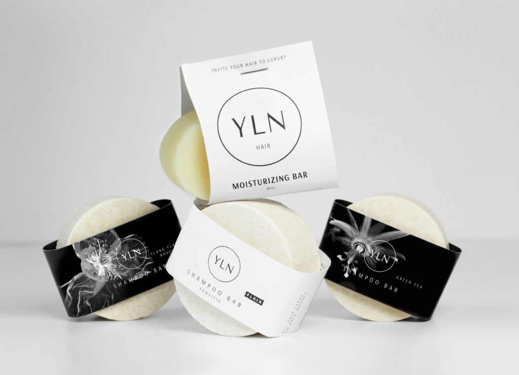 MOISTURIZING BAR und drei SHAMPOO BARs in Green Tea, Ylang Ylang / Rosewood und Plain – feste Naturkosmetik für trockene Haare, stilvoll inszeniert in einem minimalistischen Setting