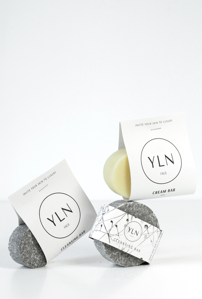 Zwei feste Gesichtspflegeprodukte – ein Cleansing Bar und ein Cream Bar – aus minimalistischer Naturkosmetik, plastikfrei verpackt und auf einem schlichten Untergrund arrangiert.